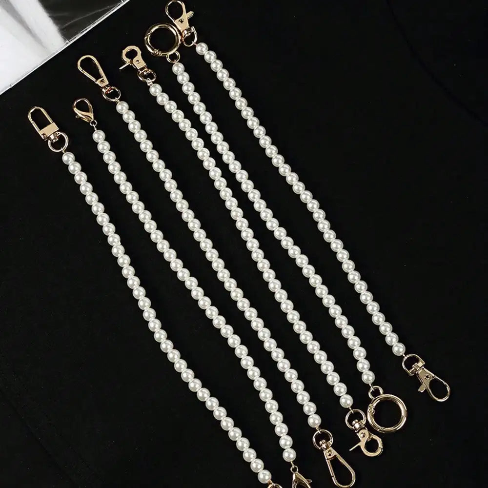 Multiple strands of elegant pearl straps with gold clasps displayed on a black surface.