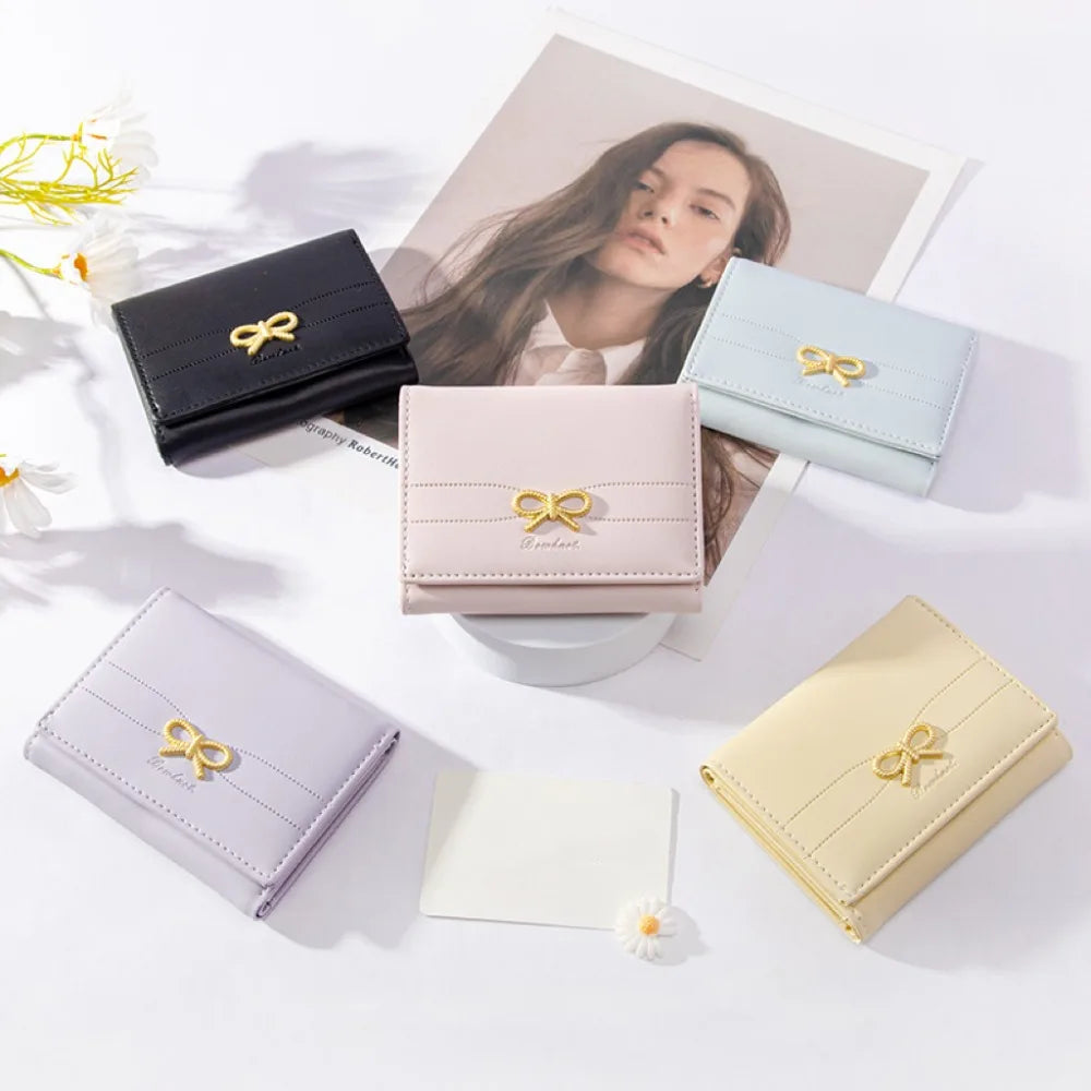 Colección de carteras de tarjetas en cuero PU trípticas en varios tonos pastel como negro, verde menta, rosa y crema.
