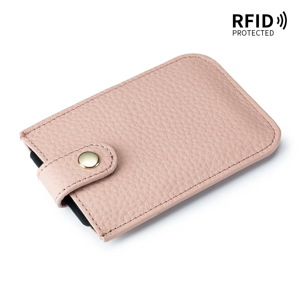 A light pink genuine leather slim card holder with a black lining and a gold-colored snap closure.