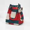 A retro knitted bucket handbag featuring a red, white, and dark green plaid pattern with black drawstring details.
