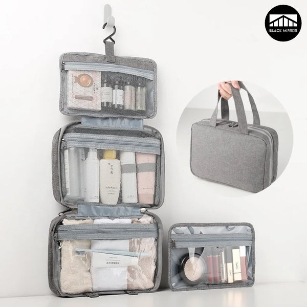 A gray travel toiletry bag with a hanging hook, open to show various skincare and grooming products.