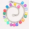 A silver chain necklace featuring colorful plastic dice in various shades of blue, green, pink, and yellow.