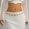 A woman wearing a white knit top and skirt accessorized with a vintage gold plated sunflower smiley face waist chain.