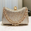 A sparkling gold rhinestone evening clutch featuring a textured surface and a pearl-encrusted closure.