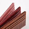 A close-up view of several slim brown and red PU leather card holder wallets stacked diagonally.
