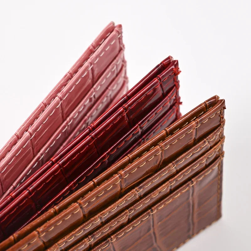 A close-up view of several slim brown and red PU leather card holder wallets stacked diagonally.