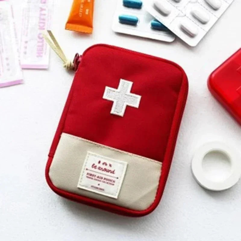 A red pouch designed for storing a portable first aid kit, featuring a white cross emblem and a beige patch.