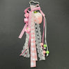 A pink and white checkered fabric bag charm keychain featuring a strawberry-shaped charm and dangling pink and green beads.