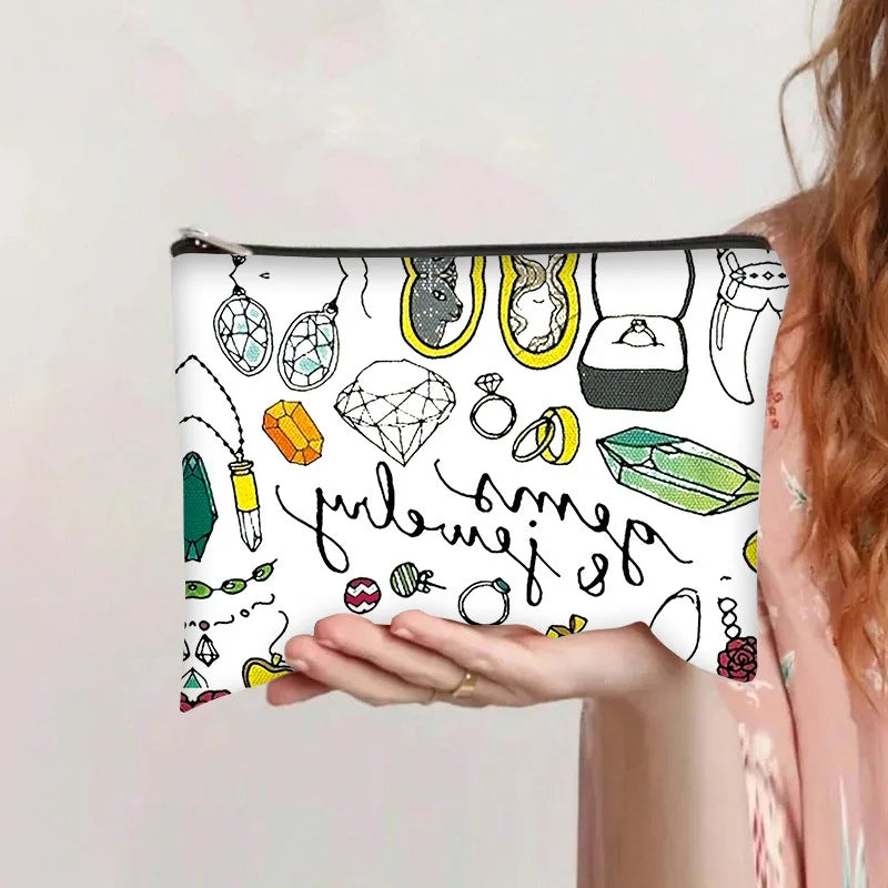 Una mano sostiene una bolsa de almacenamiento cosmético con un dibujo lineal de joyería y artículos de belleza.