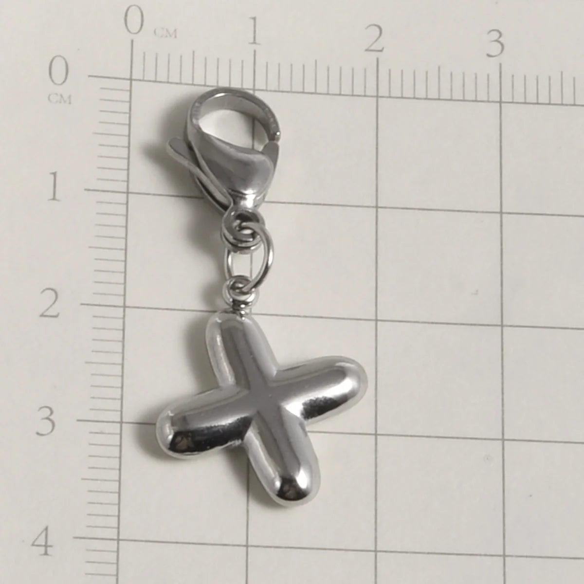Silver stainless steel alphabet letter charm shaped like a cross with a lobster clasp