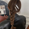 A woman's hair is styled in a braid with silver metal star hairpins attached to the hair.