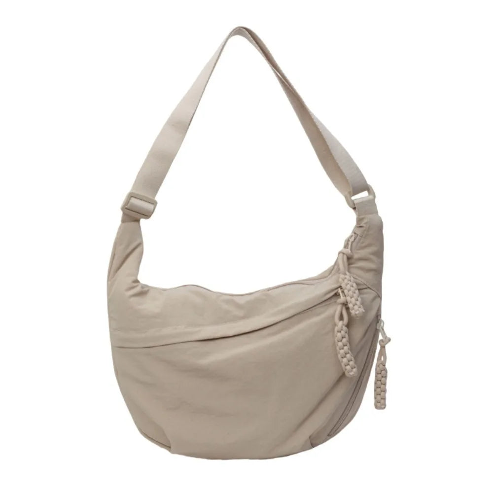 A beige canvas crossbody shoulder bag with a drawstring closure.