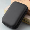 A black multi-functional storage shoulder bag resting on a light-colored box.