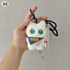 Colgante de peluche de gato blanco con ojos azules y un lazo azul, sostenido por una mano.
