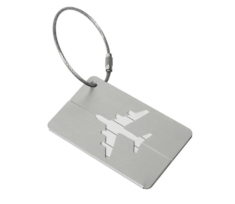 A silver aluminum luggage tag with a braided cord attached.