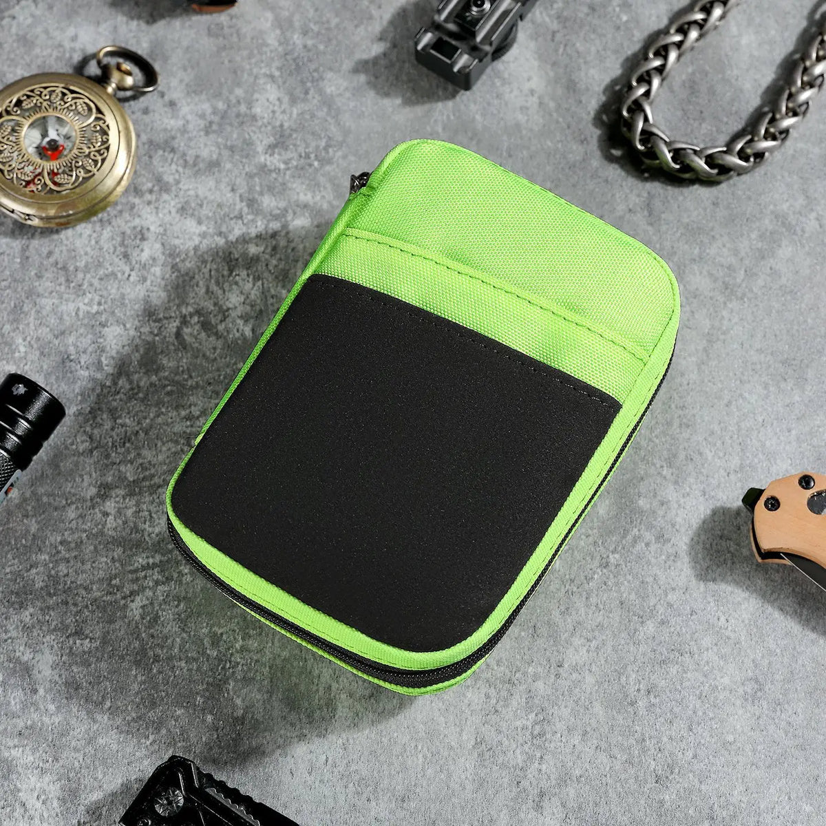 A bright lime green zippered pouch with a black interior is shown on a gray surface.