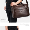 A dark brown genuine cowhide leather briefcase bag carried by a person in casual attire.
