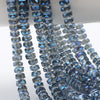 A close-up of blue and clear faceted crystal glass beads strung together for jewelry making.