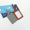 A set of two custom PU leather luggage tags, one gray and one brown, with a white rectangular detail.