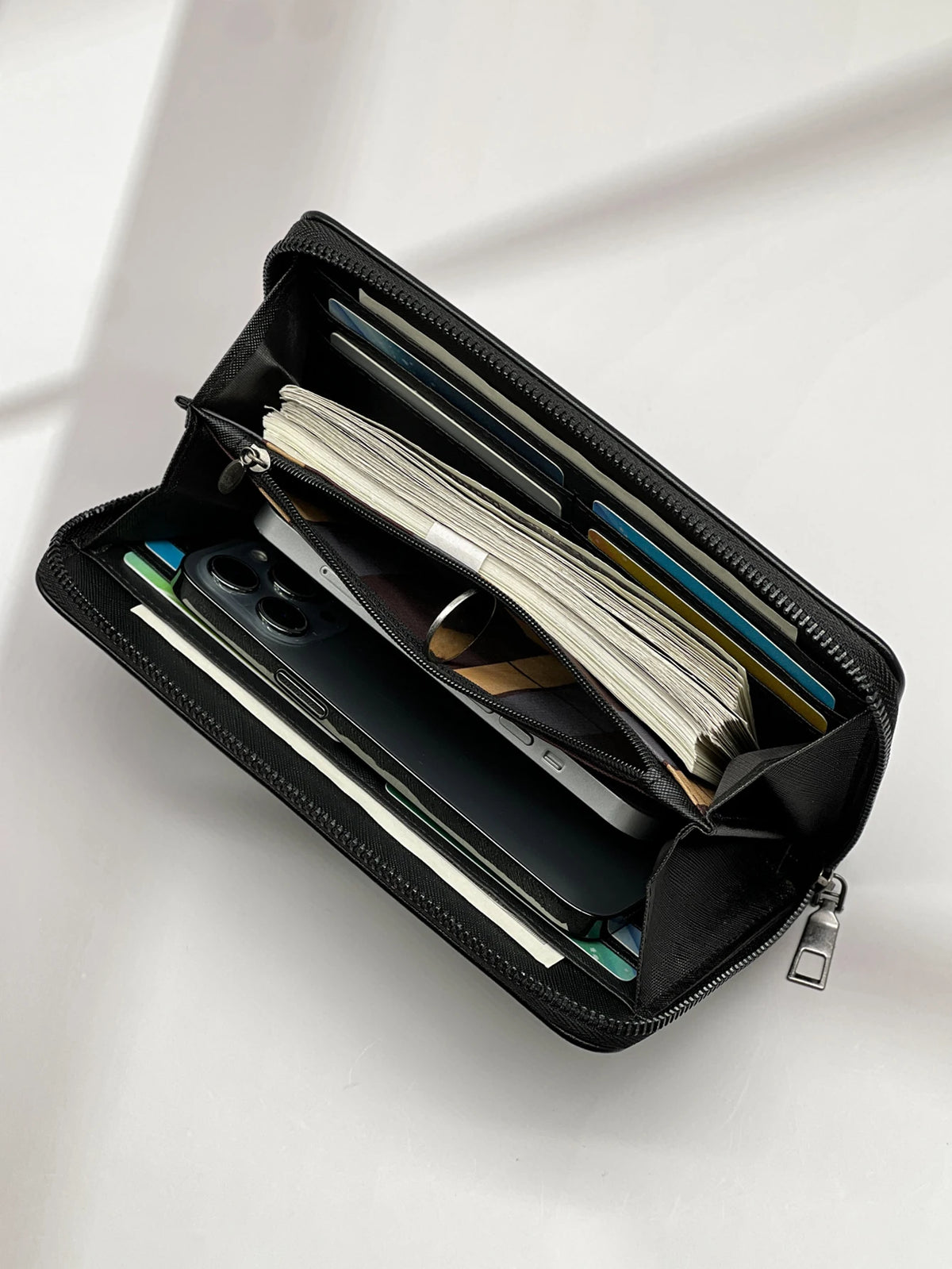 Black multi-card men's commuter wallet open showing various cards and a smartphone.