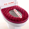 A maroon plush waterproof toilet seat cover is shown inside a white toilet bowl.
