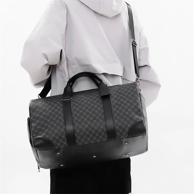 A black leather-trimmed travel duffle bag carried by a person wearing a white hooded jacket.