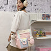 A young woman models a pink and white Kawaii Harajuku backpack with a laptop compartment in a retail display.