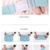 A set of seven folding travel organizer bags in light blue and mint green fabric.