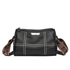 A black luxury cowhide shoulder bag with white stitching and a leather strap.