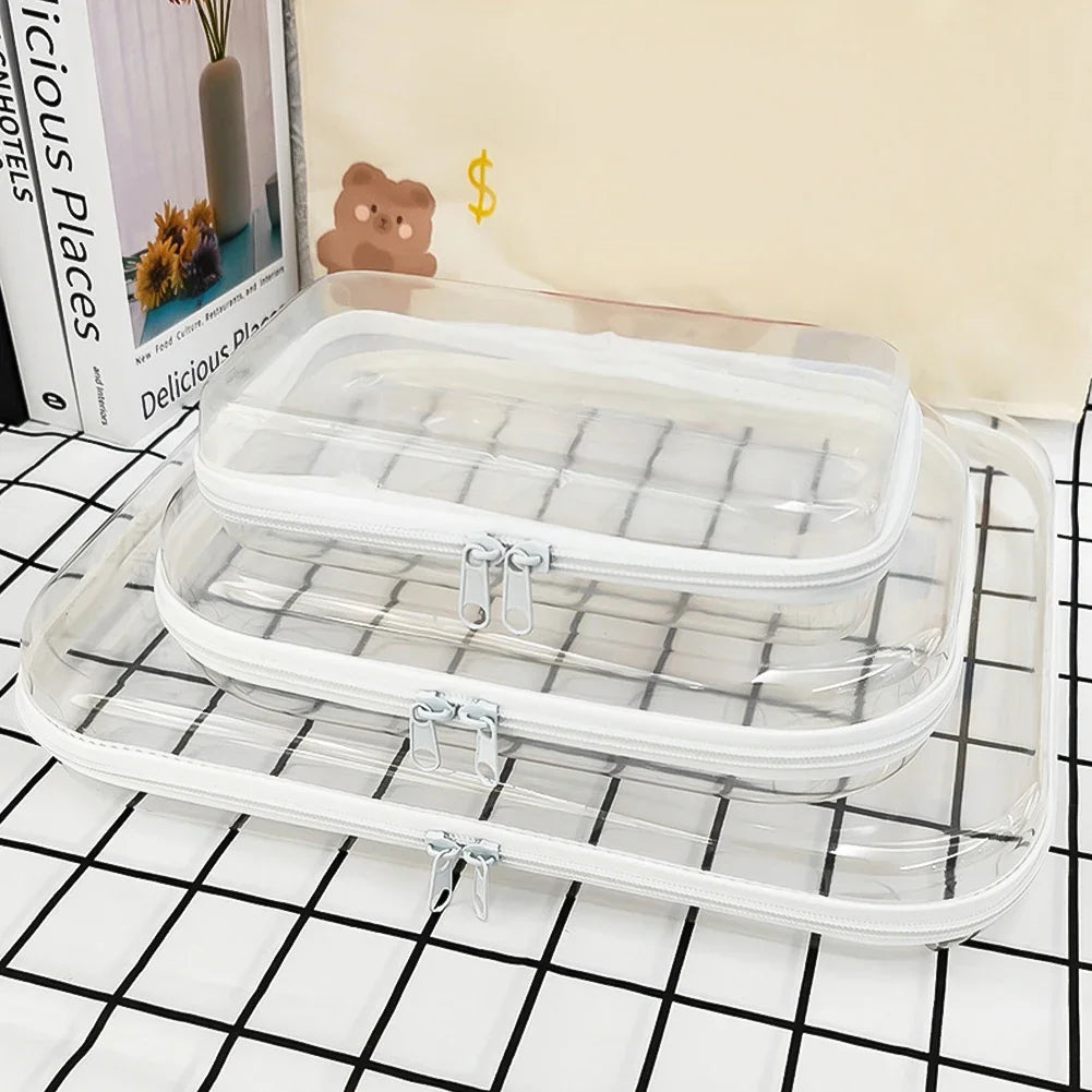 A clear plastic storage pouch set with a lid and a base, displayed on a black and white grid surface.