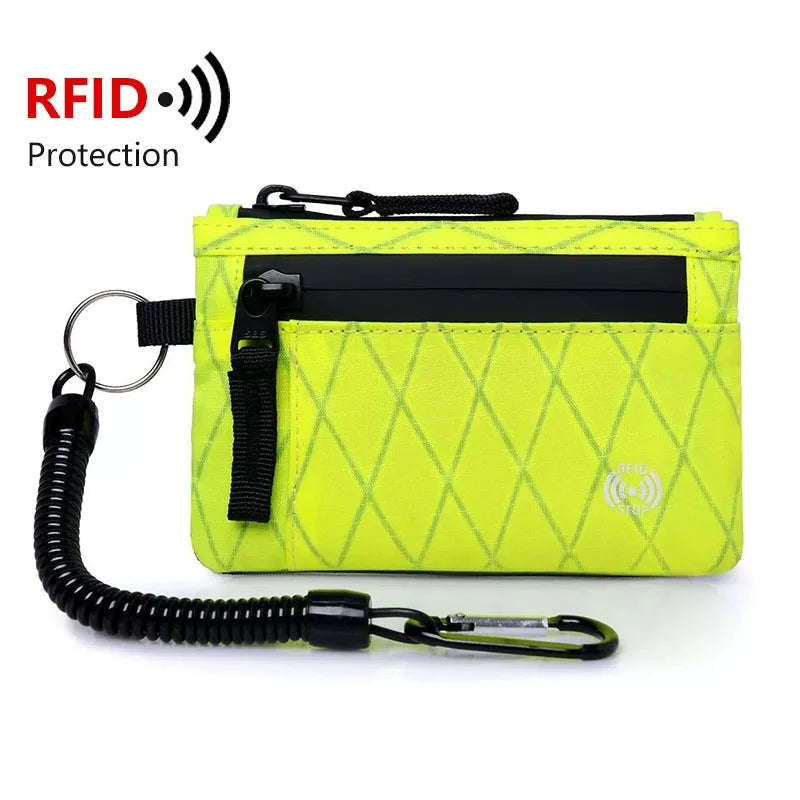 A bright yellow patterned RFID blocking travel wallet with a black carabiner attached.