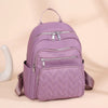 A purple waterproof women's travel backpack with zippered compartments is shown against a light background.