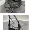 Schwarz-weißes Zebra-Print-Crossbody-Taschen, präsentiert auf einem klaren Acrylständer.