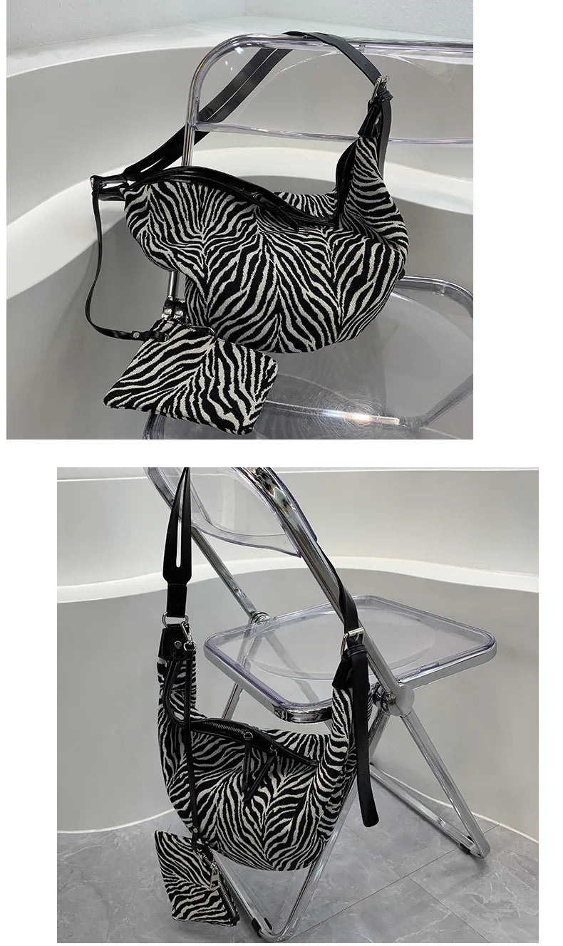 Schwarz-weißes Zebra-Print-Crossbody-Taschen, präsentiert auf einem klaren Acrylständer.