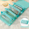 A teal portable detachable makeup bag with multiple clear zippered compartments resting on a white fluffy surface.