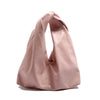 A light pink leather minimalist crossbody tote bag folded and displayed against a white background.