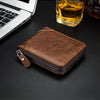 A brown retro PU leather men's wallet lying on a dark surface next to a laptop and a glass of amber liquid.