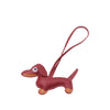 A small, reddish-brown leather dachshund charm with a loop for a keychain.
