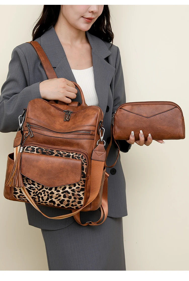 A woman holds a brown retro PU leather travel backpack with a leopard print panel and a matching clutch.