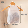 A white honeycomb mesh laundry bag is shown hanging on a wooden hanger against a light wall.