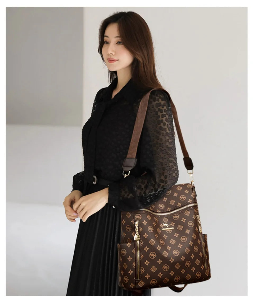 A woman models a brown leather backpack with gold hardware against a light background.