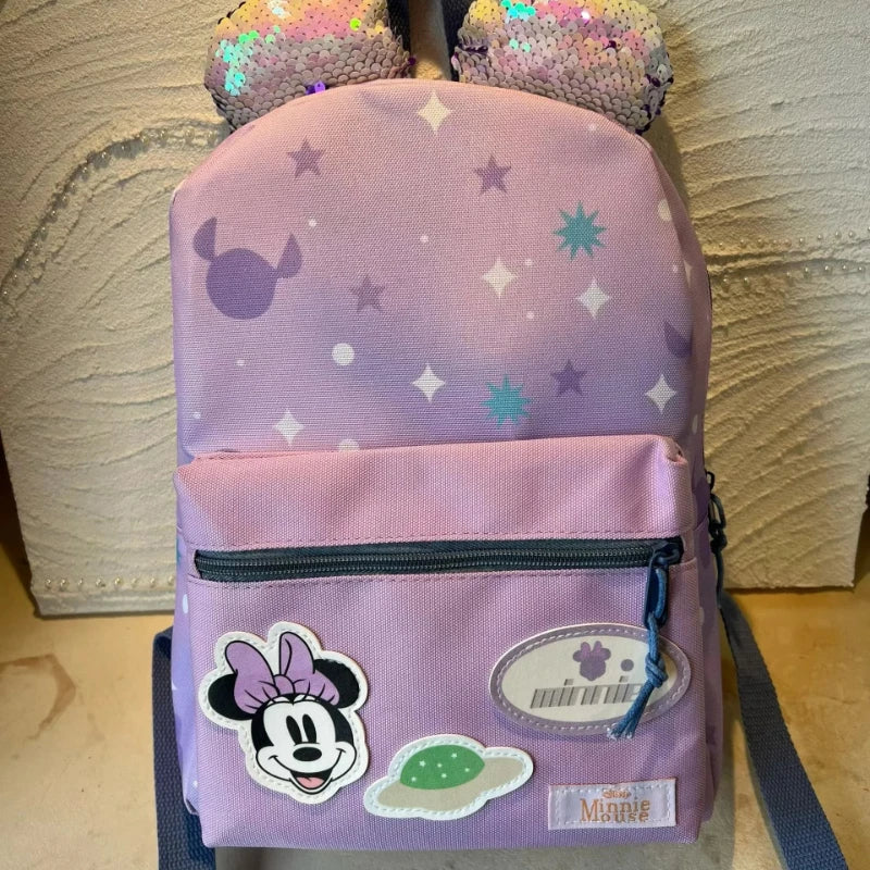 A pink Minnie Mouse themed backpack with a cow print design and purple glitter accents.