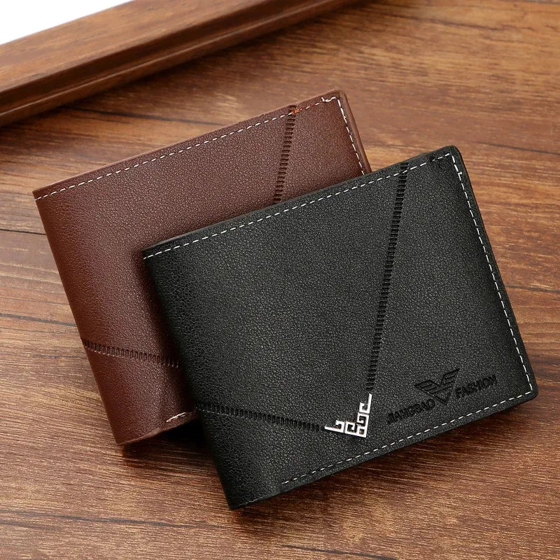 A dark gray leather bifold wallet with stitching and a logo is shown resting on a wooden surface.