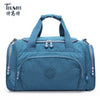 A teal nylon travel duffle bag with handles and zippers is shown against a white background.