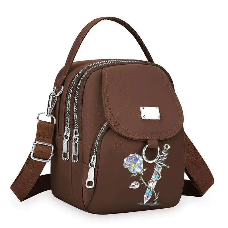 Sac bandoulière marron floral avec fermeture éclair et sangle en cuir.
