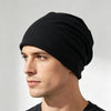 A man wearing a black slouchy knit beanie hat.