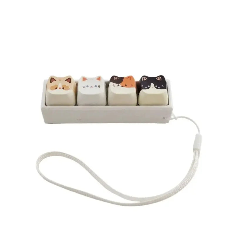 A set of five cat-shaped keycaps used as a fidget toy with a white plastic tray and lanyard.