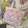 A pink transparent shoulder tote bag decorated with floral elements and cute charms.
