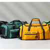 Four tactical backpacks in black, green, and yellow are displayed on a white surface.