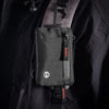 Black RFID blocking travel wallet attached to a gray jacket with a carabiner clip